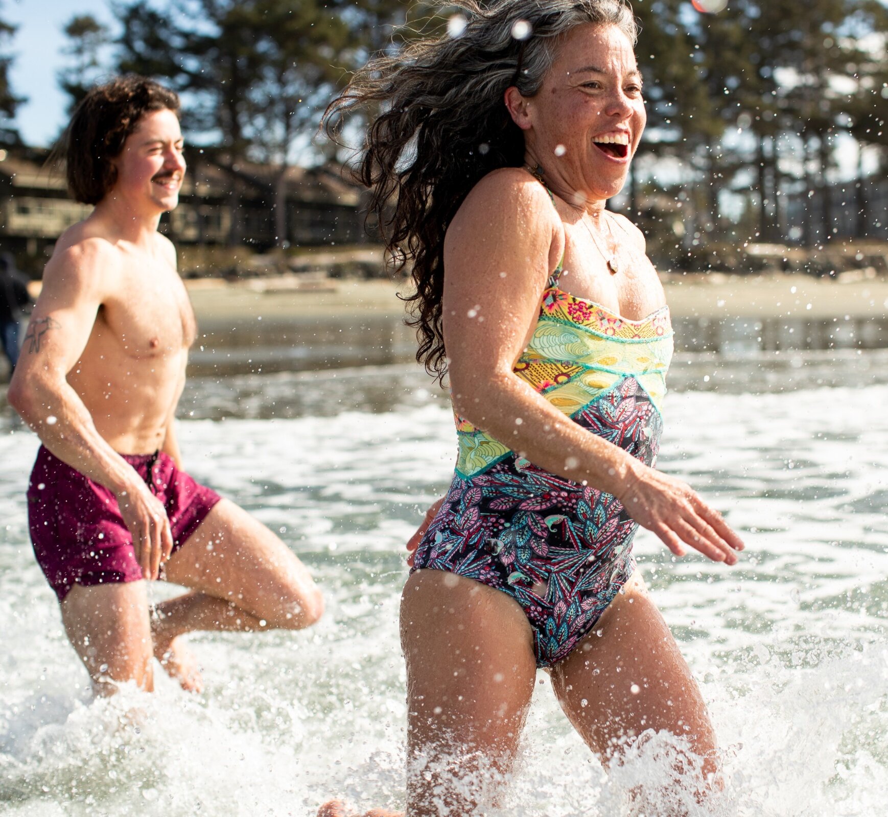 People running from the sauna into the ocean waves